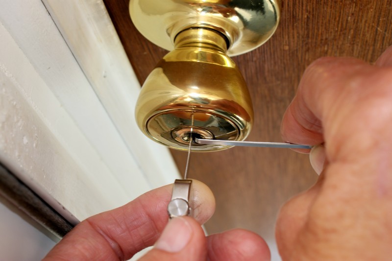 Green Locksmith technician installing a door lock in Los Angeles